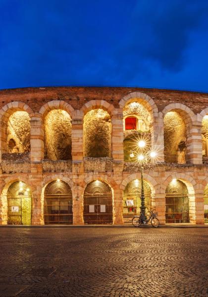 Arena di Verona illuminata di notte, architettura romana.