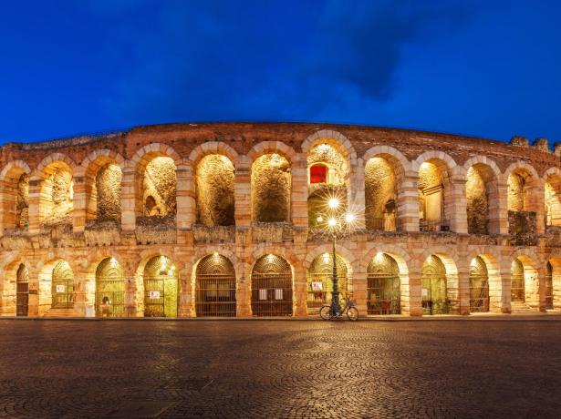 Arena di Verona illuminata di notte, architettura romana.