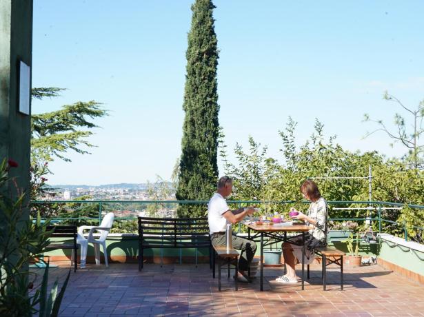 Two people having breakfast on a terrace with a panoramic view.