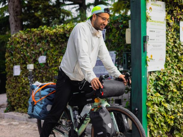 Cycliste au camping avec vélo chargé de sacs.